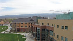 University Center in foreground, two residence halls with about 1,000 beds beyond, and a crane at the location of a third residence hall under construction