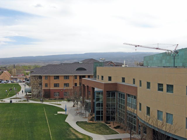 University Center in foreground, two residence halls with about 1,000 beds beyond, and a crane at the location of a third residence hall under construction