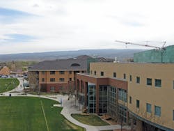University Center in foreground, two residence halls with about 1,000 beds beyond, and a crane at the location of a third residence hall under construction University Center in foreground, two residence halls with about 1,000 beds beyond, and a crane at the location of a third residence hall under construction