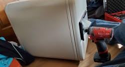 Image 5: After you peel back the paper label on the safe, use your drill and angle slightly in. Image 5: After you peel back the paper label on the safe, use your drill and angle slightly in.