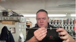 Jason Jones displays one of his lever-lock picks. He applies tension via the lever on the right, while the dial controls the tapping. Jason Jones displays one of his lever-lock picks. He applies tension via the lever on the right, while the dial controls the tapping.