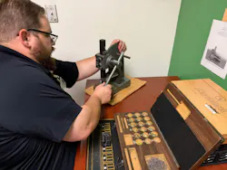 Turnbow works the capping machine in the lock shop.